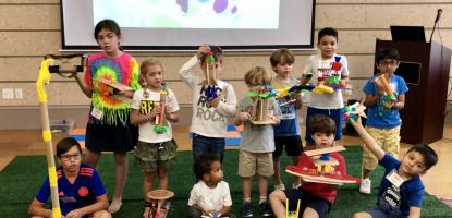 Children displaying recycled crafts