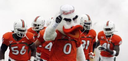 Sebastian the Ibis running in front of UM football players