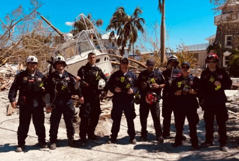 Coral Gables firefighters standing in front of debris after Hurricane Ian