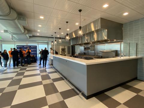 New diner area finalized with no furniture. People stand in the far background