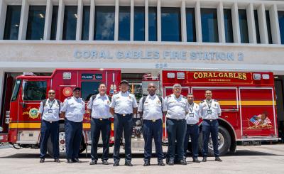 Fire fighters from Cartagena de Indias stand in front of Coral Gables firetruck